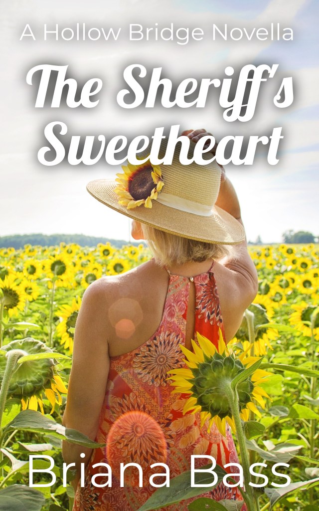 A woman standing in a sunflower field, wearing a colorful dress and a hat, looking away from the camera. The title 'The Sheriff's Sweetheart' is prominently displayed at the bottom.