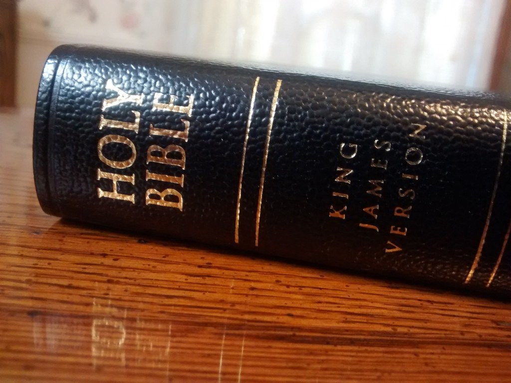 Close-up of a black leather-bound Bible with the title 'HOLY BIBLE' and 'KING JAMES VERSION' embossed in gold.